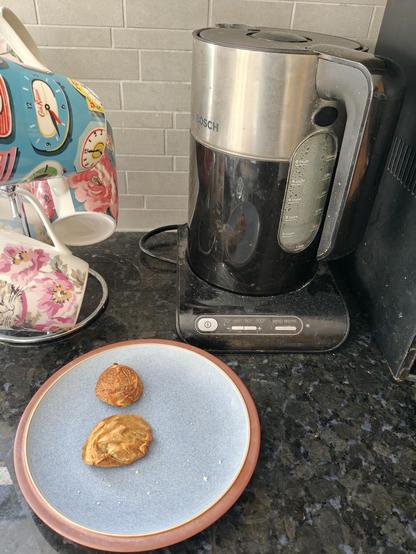 A kettle with two used teabags on a plate in front