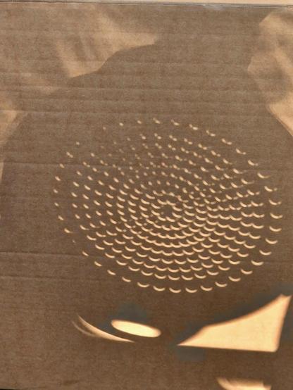 Shadow of a colander. Rather than the drainage holes being circles, they're crescents