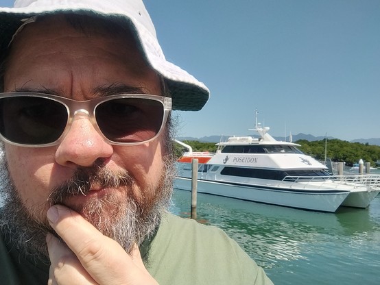 Me, stroking my chin thoughtfully, in the background is a moored boat named Poseidon 