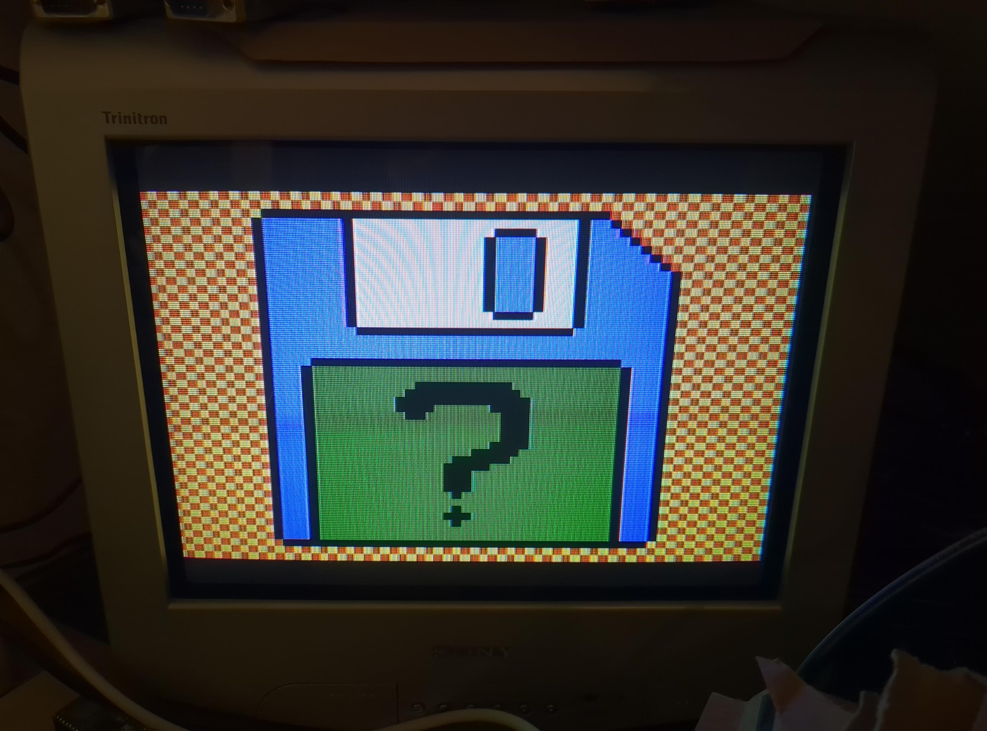 Photo of a TV screen showing a low res drawing of a blue floppy with a green label with a question mark written on it.