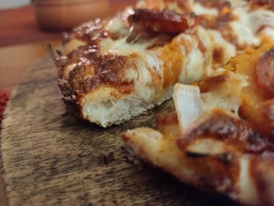 Close up crumb shot of a slice of the pizza. It's very bubbly
