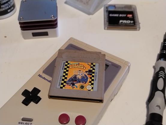 A Game Boy cartridge, Crash Dummies, on top of an original Game Boy console