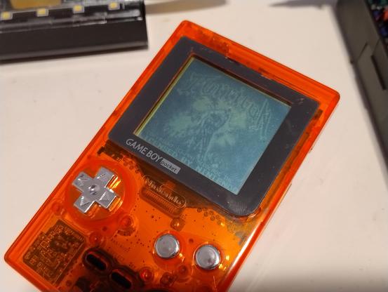 A Game Boy Pocket displaying the start screen for Turrican