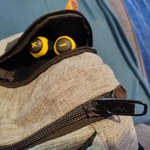 Top down view of a backpack with the top of two screwdrivers visible and it kind of looks like they're eyes in a face with a below suggesting a tongue sticking out slightly