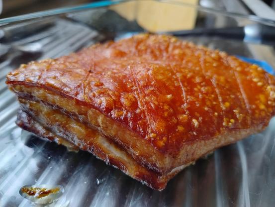 Roasted pork belly in a tray with a good even looking crackling layer