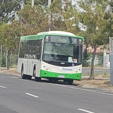 A bus parked by the side of the road, the destination display says