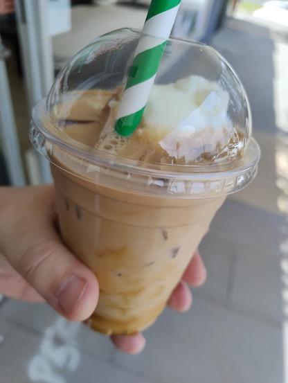 Iced coffee in a transparent cup with ice cream on top