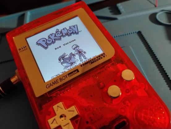 A Game Boy Pocket displaying the start screen for Pokemon Red