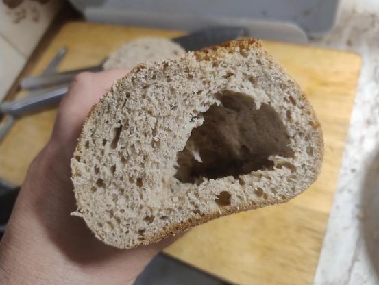 Inside of a loaf of bread cut at one end revealing a huge air bubble in it
