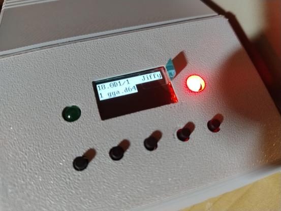 A small screen in a box surrounded by buttons and LEDs, selected item on the screen is gga.d64