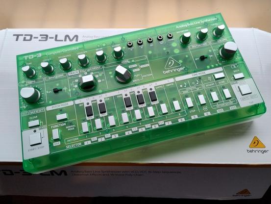 A lime green Behringer TD-3 on top of a box 