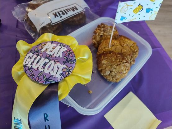 Some Anzac bikkies on a table with a prize ribbon next to them reading 