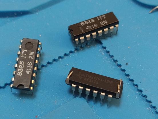 Two 4116 chips and a 4164 with two of its legs bent back, one soldered to a bit of wire
