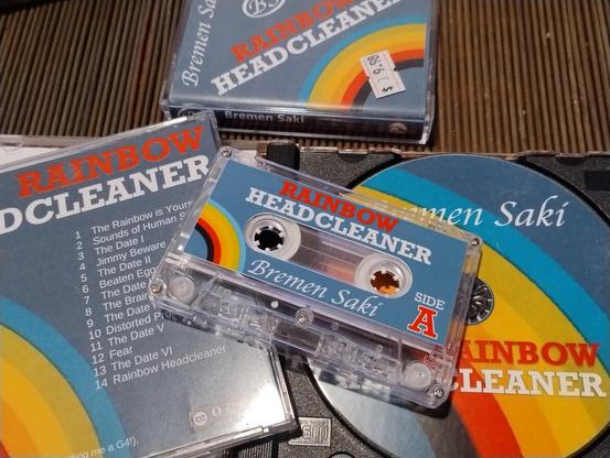 Cassette and CD copies of Rainbow Headcleaner showing off their lovely labels and case inserts.