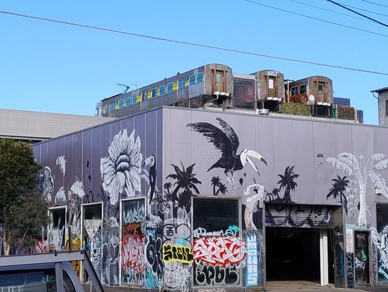 Rear of a building with three old Hitachi trains on the roof