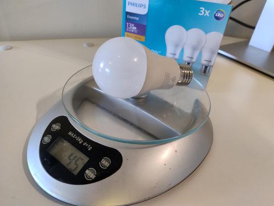 A Philips led light bulb on kitchen scales at work, the display indicating 45 grams of bulb. 