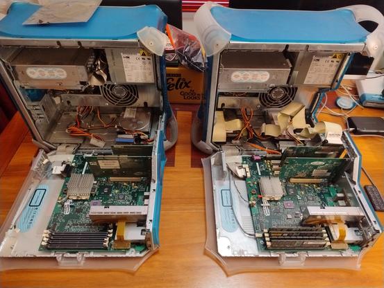 Two Blue and White G3 Macs with the cases open, showing the motherboards and internal case contents