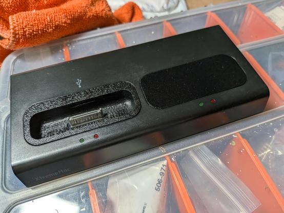 A black docking station for two iThings one with an iPod 4th gen adaptor and the other with a blank cover