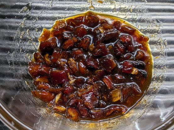 Dates in a bowl, chopped up and soaking in a dark syrup